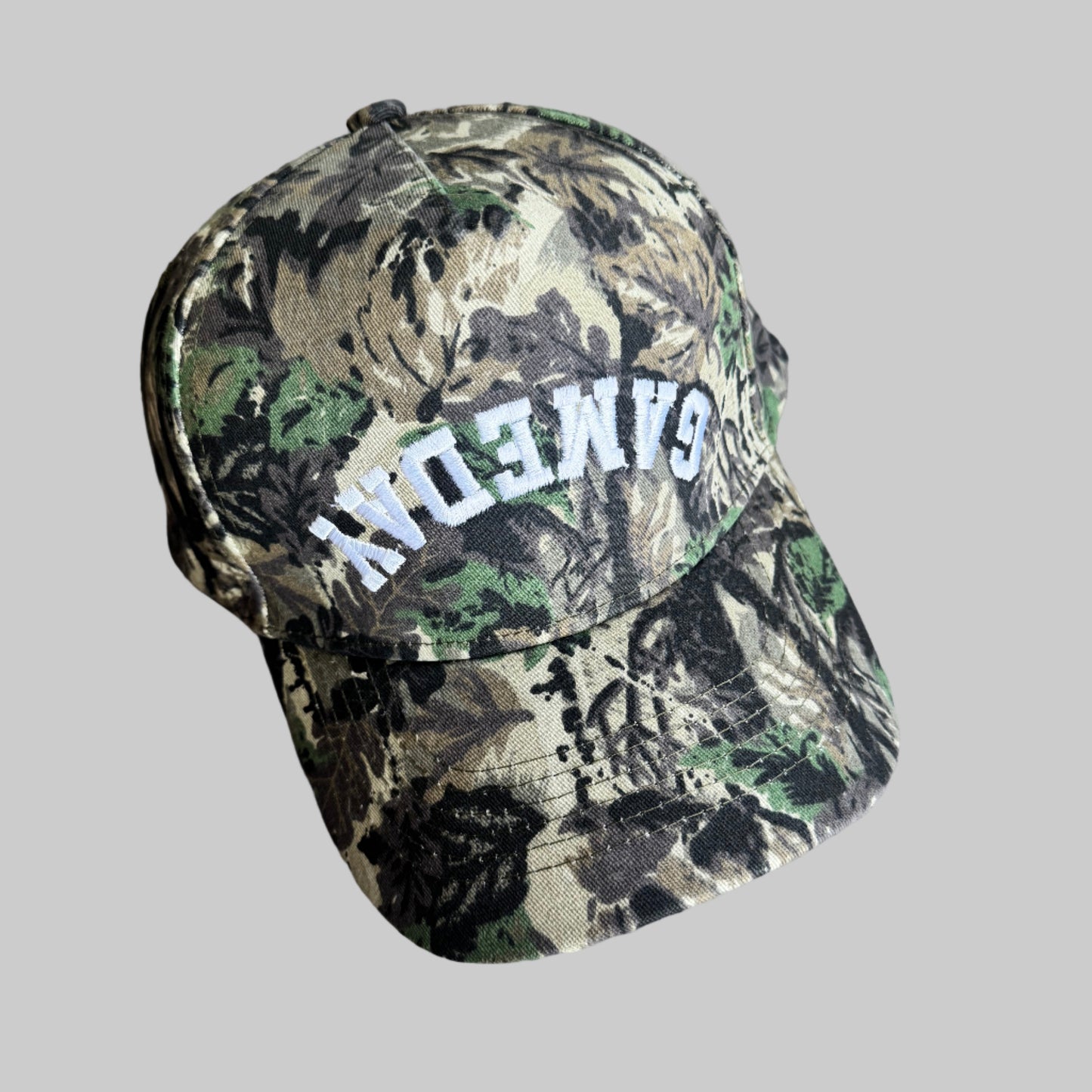 Camouflage-patterned baseball style hat with 'GAMEDAY' embroidered on a hat