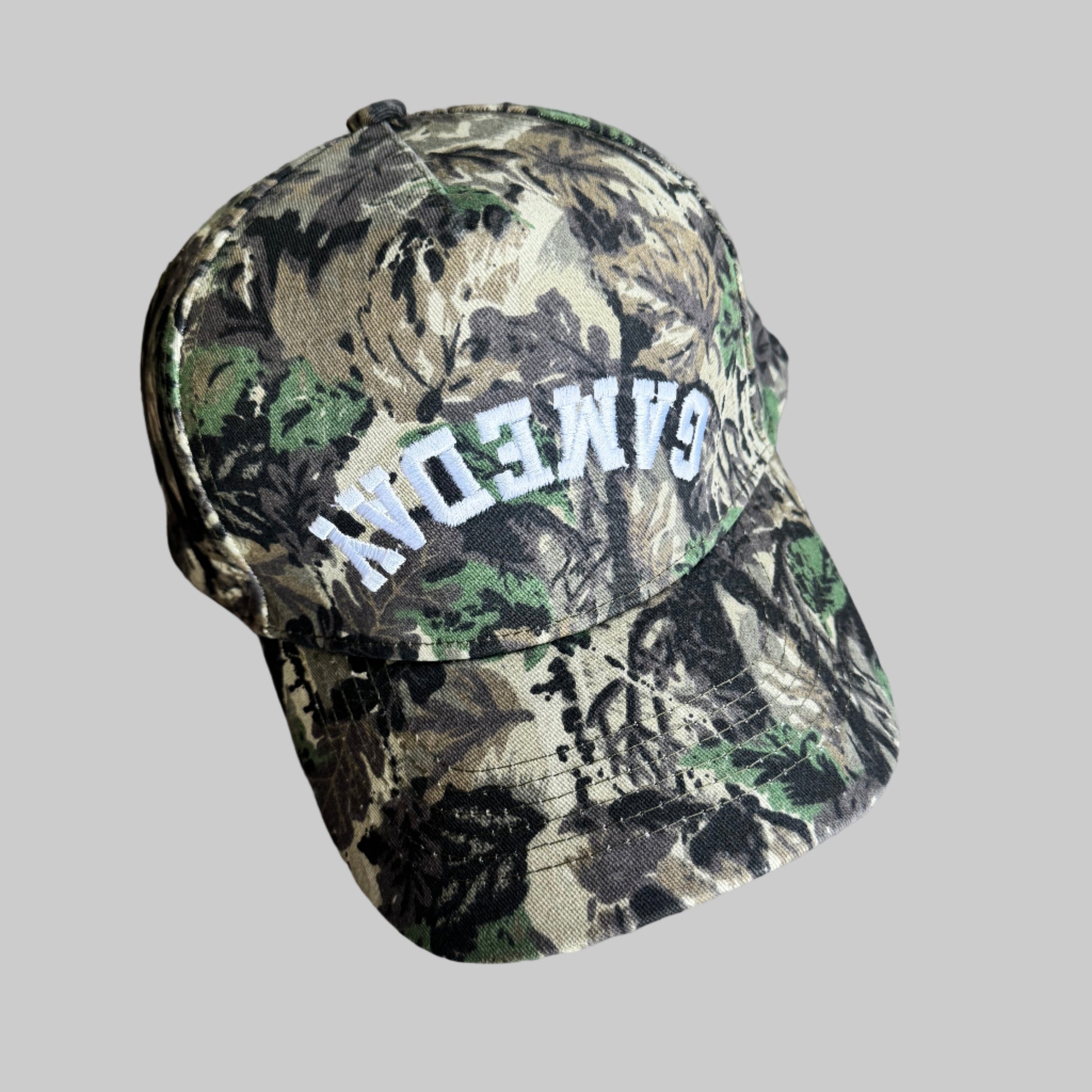 Camouflage-patterned baseball style hat with 'GAMEDAY' embroidered on a hat